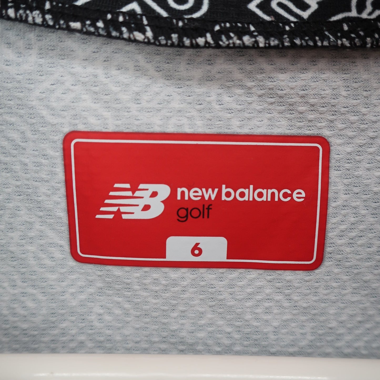 New Balance golf(ニューバランスゴルフ) 半袖モックネックシャツ 黒白ロゴ文字柄 メンズ 6 012-4266002 A